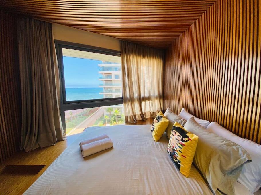 a bedroom with a large bed with a large window at Marina Chalet Ocean View - By AppartAli in Casablanca-Port