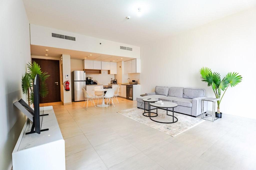 a living room with a couch and a table at Reem Island Modern 1BR Pool, Gym, City View in Abu Dhabi