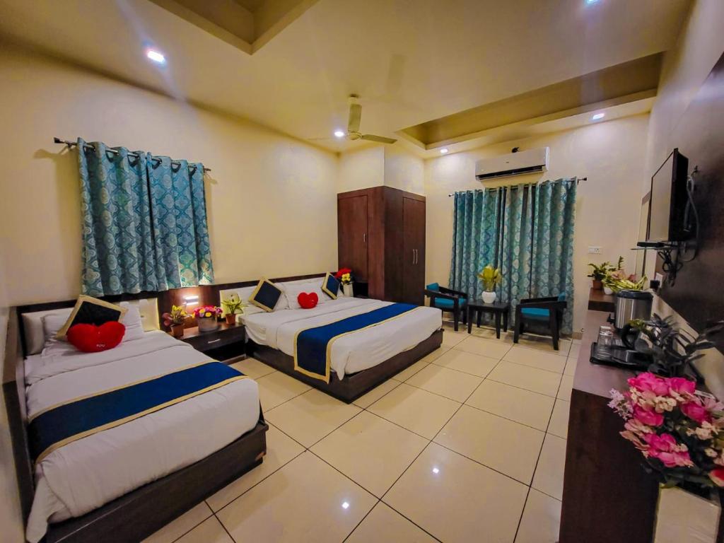 a hotel room with two beds and a television at Hotel Paradise inn in Udaipur