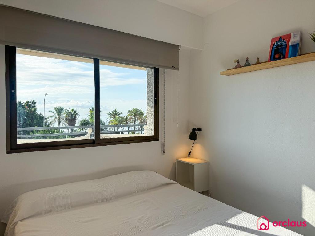 a bedroom with a bed and a large window at El Apartamento in Benicàssim