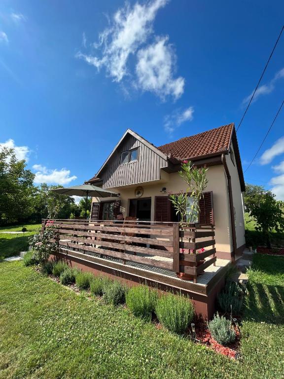 a house with a wooden fence in the yard at Diófás Ház in Siklós