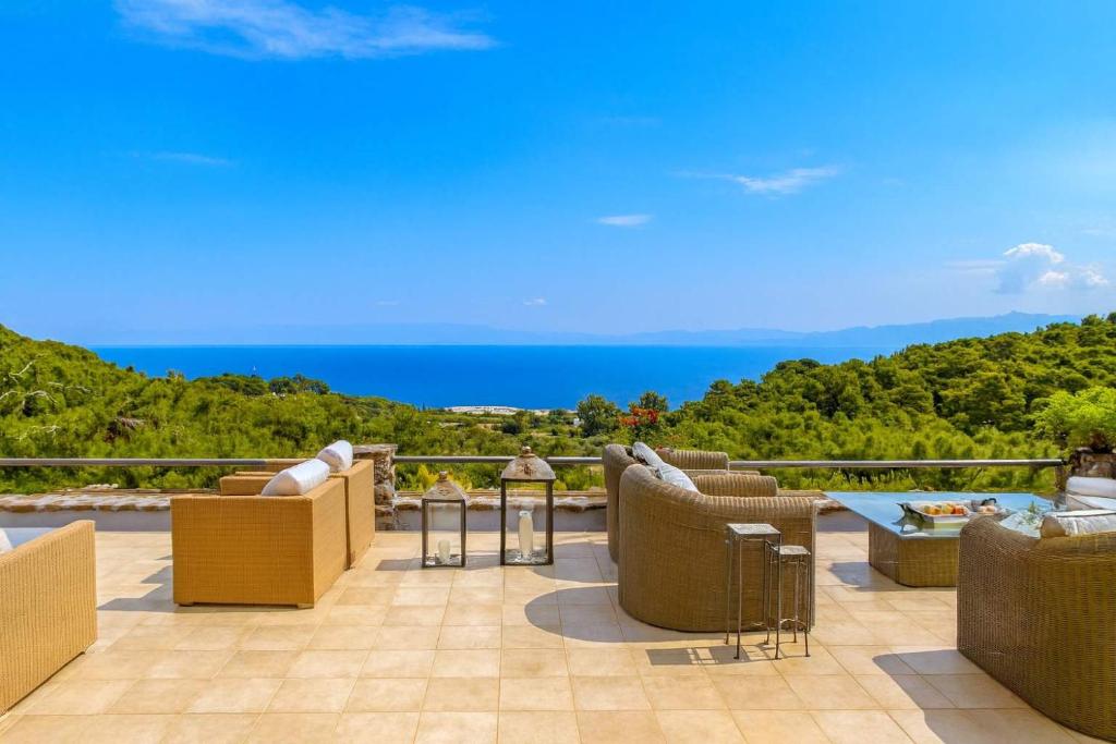 a patio with chairs and a view of the ocean at Villa Laurette Kratigos - Private Escape with Views in Pligónion