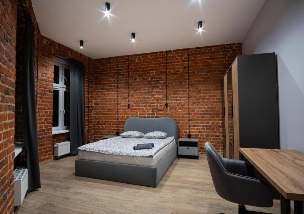 una camera da letto con un letto e un muro di mattoni di DREAM APARTMENTS - Wschodnia 34 a Łódź