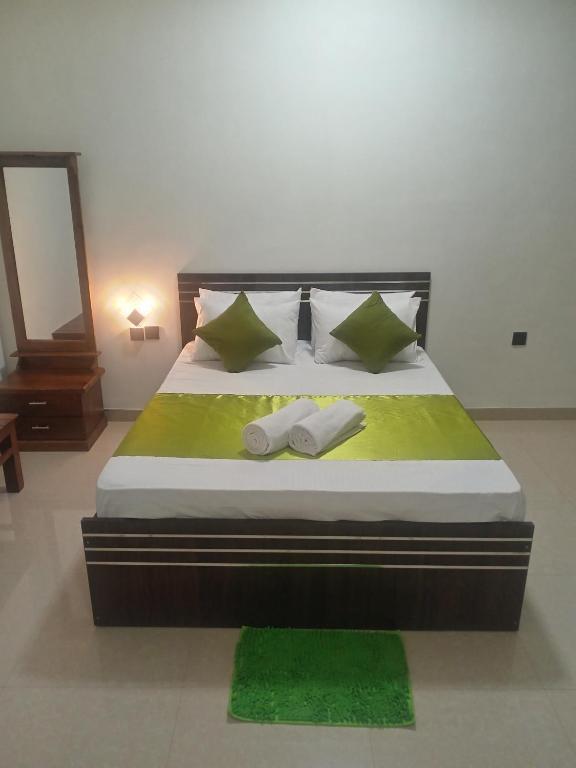 a bedroom with a bed with two towels on it at Mid City Apartment in Badulla
