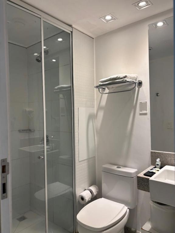 a bathroom with a toilet and a glass shower at Linhares Design Hotel 407 in Linhares