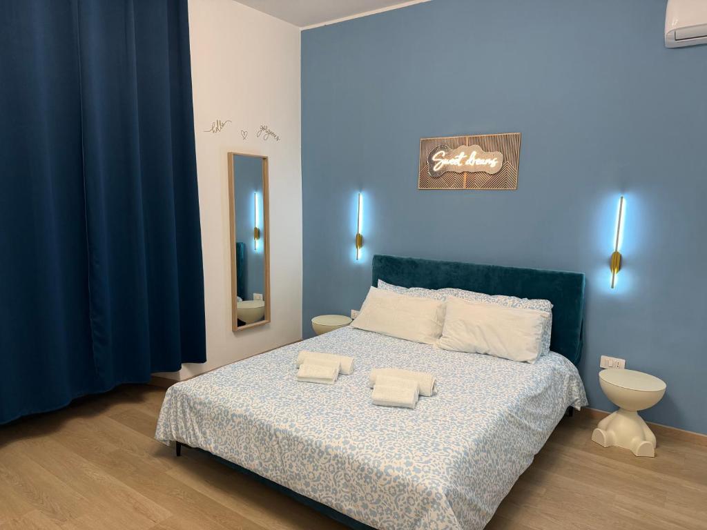 a blue bedroom with a bed with two towels on it at Lodevì in Foggia