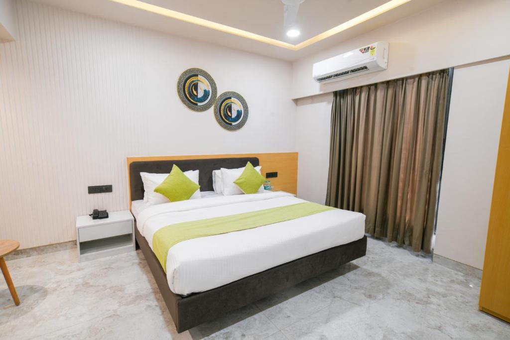 a bedroom with a large white bed with yellow pillows at The Byke Express - Near Gopur Square in Indore