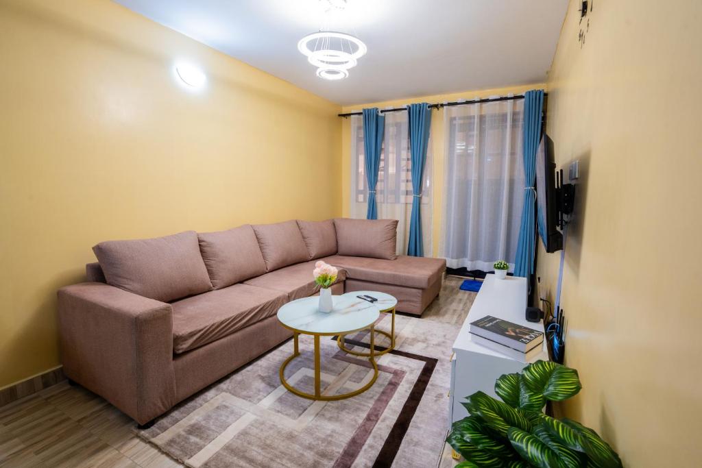 een woonkamer met een bank en een tafel bij Shwari Home Stays in Kisii