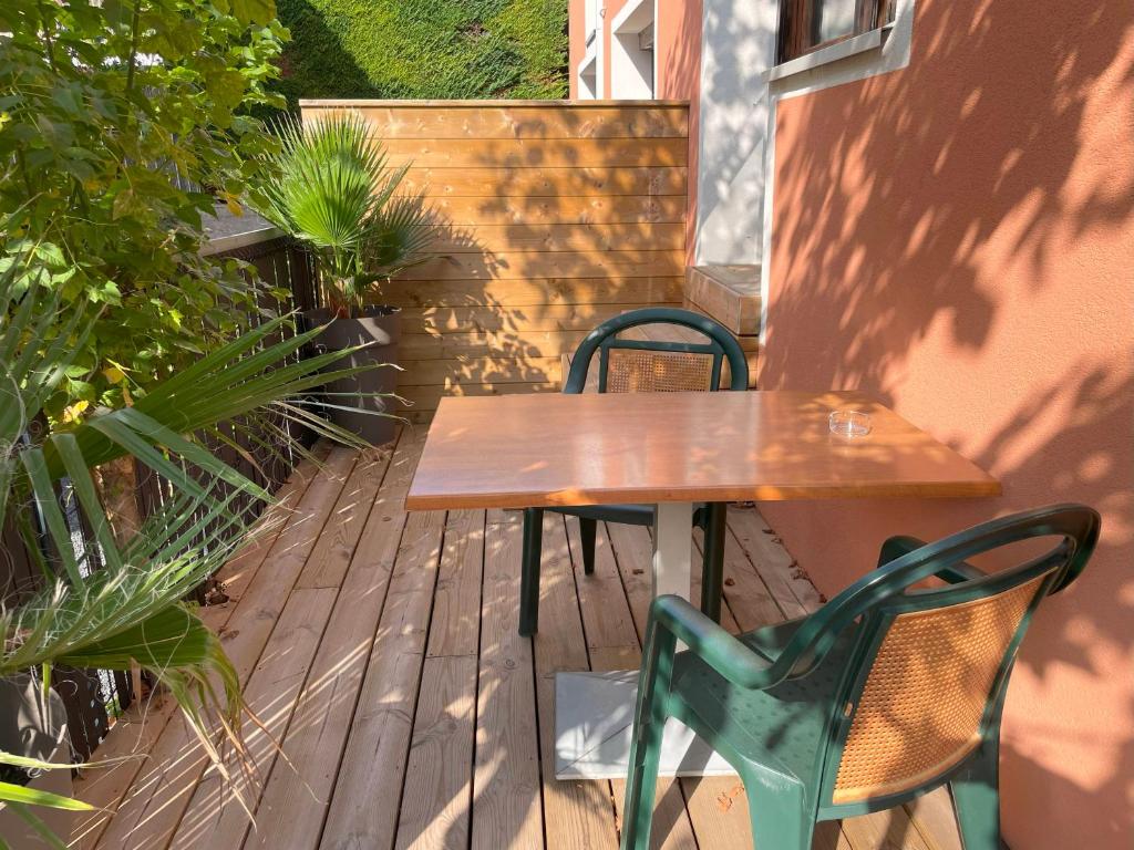 ブールゴアンにあるStudio Duplex le Jungle - Bourgoin Centreの木製デッキ(木製テーブル、椅子付)