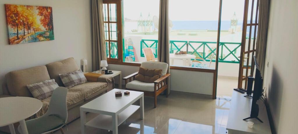 a living room with a couch and a table at Aguycan - Bungalow with ocean views in San Bartolomé de Tirajana