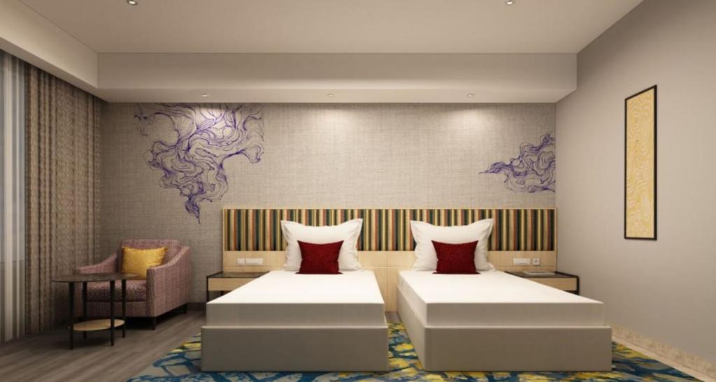 a bedroom with two beds and a chair at Vivanta Kochi, Aluva in Alwaye