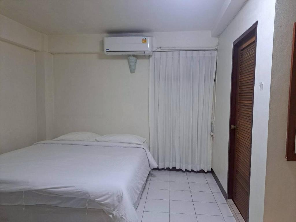 a bedroom with a white bed and a heater at BaanSathorn21 in Bangkok