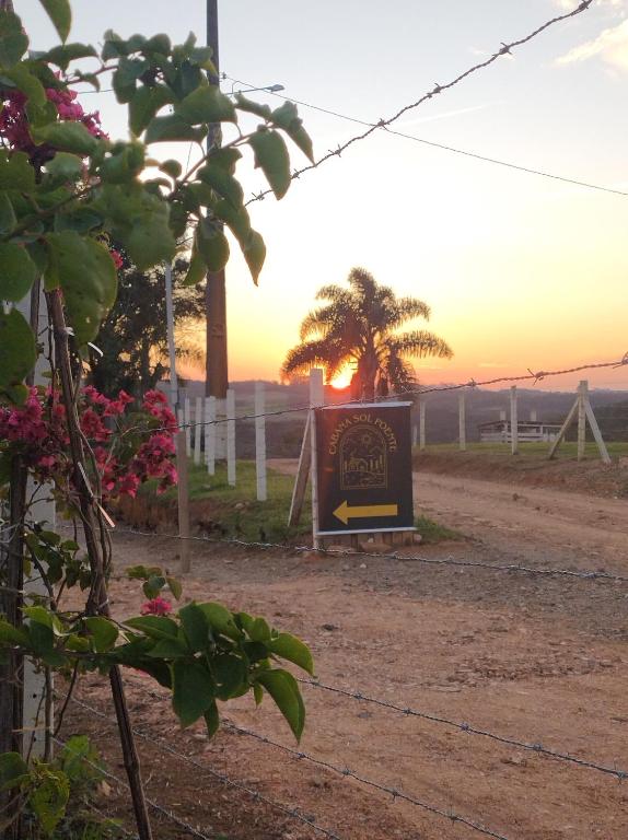 a sign sitting on the side of a dirt road at Cabana Sol Poente PR in São José dos Pinhais