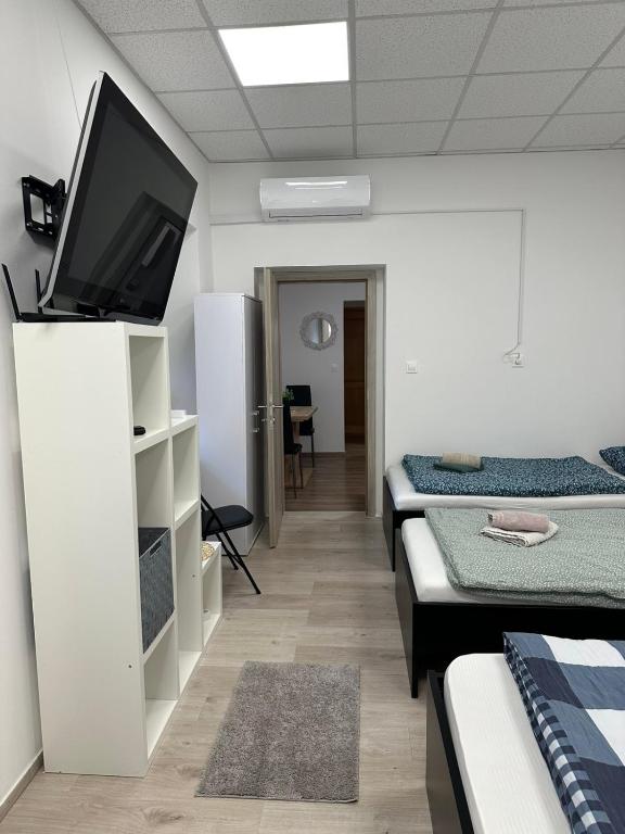 a room with three beds and a flat screen tv at Apartma Center Ljutomer in Ljutomer