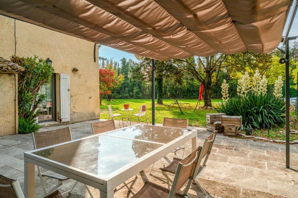 a table and chairs under an umbrella on a patio at Chambre D'hôtes Nature in Cabannes
