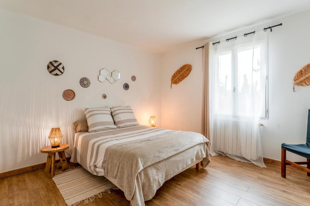 a white bedroom with a bed and a window at Chambre D'hôtes Nature in Cabannes