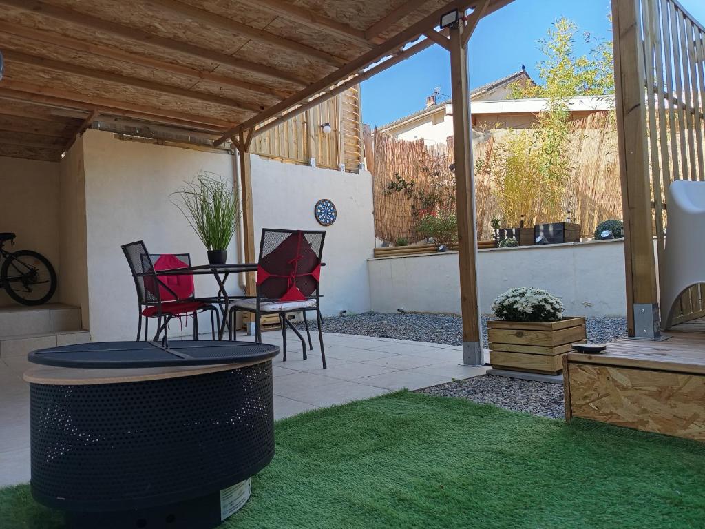 a patio with a table and chairs under a pergola at Résidence des 4 saison in Cransac