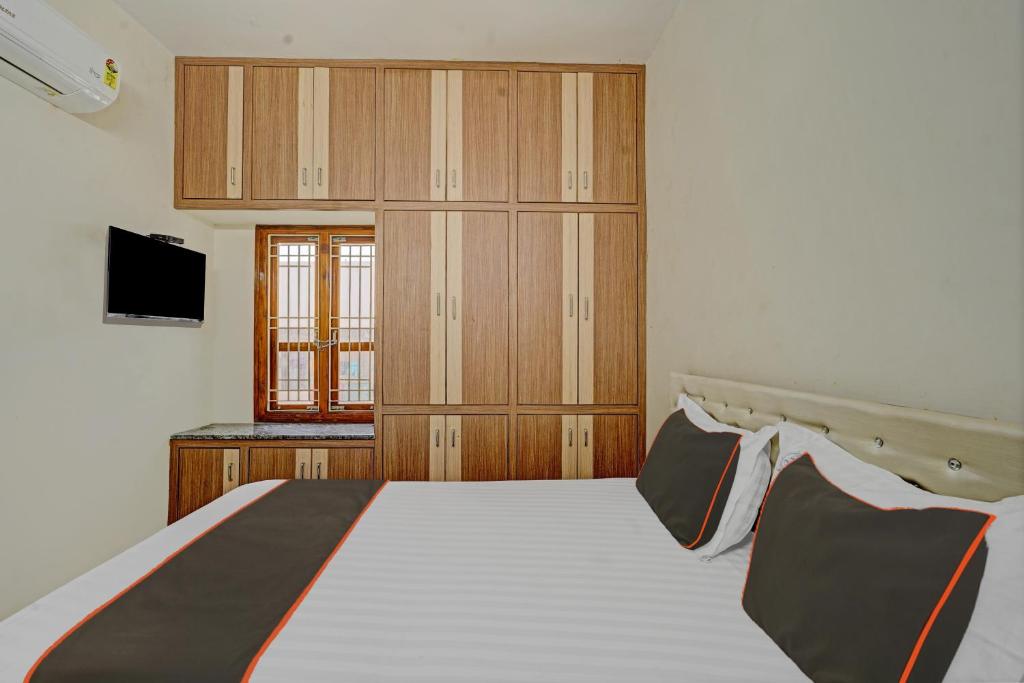 a bedroom with a large bed and a television at Collection O Ns Service Apartment in Tirupati