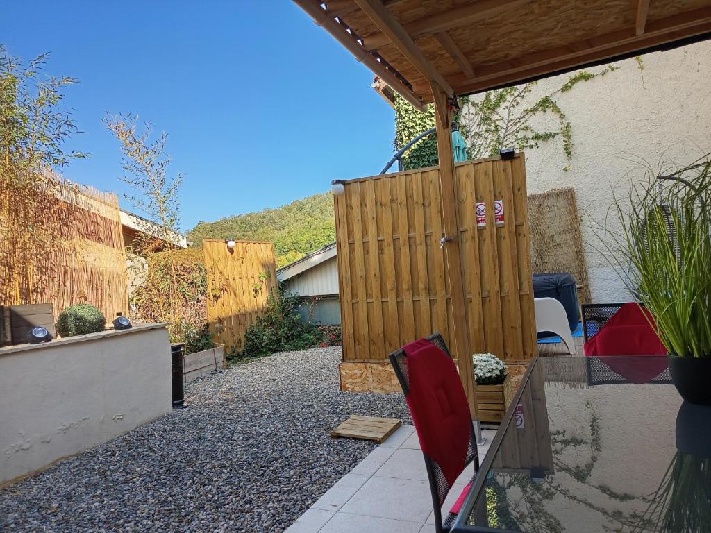 a garden with a wooden gate and a patio at Résidence des 4 saison in Cransac