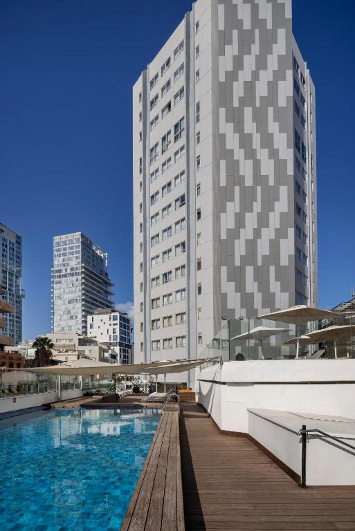 特拉维夫大都会酒店的一栋建筑前有一座游泳池