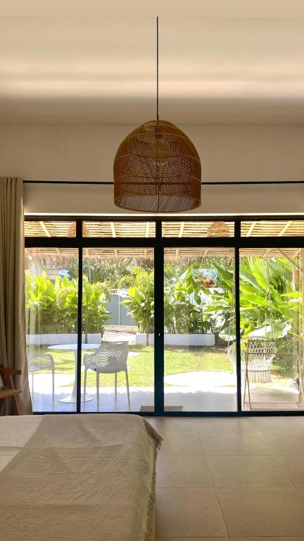 爱妮岛CASA BUKO Tropical Homes El Nido的一间卧室设有一张床和一个大型玻璃窗