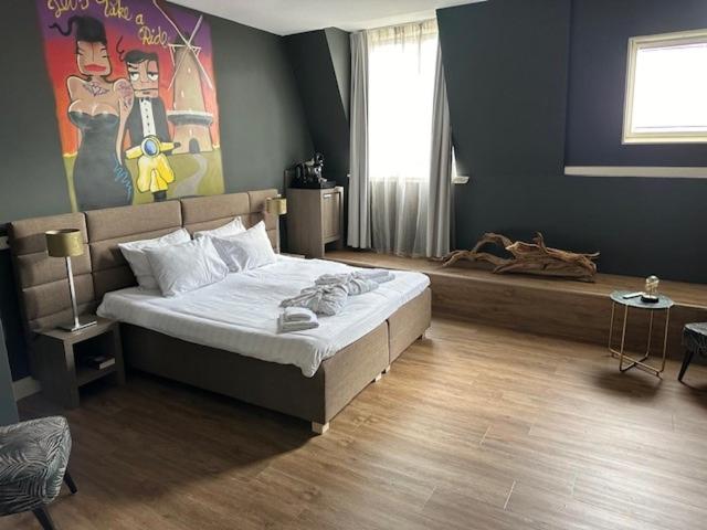 a bedroom with a bed and a painting on the wall at Tres Boutique Hotel in Gorinchem