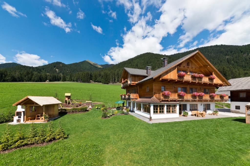 eine Luftansicht eines Blockhauses auf einem Feld in der Unterkunft Festnerhof in Gsieser Tal