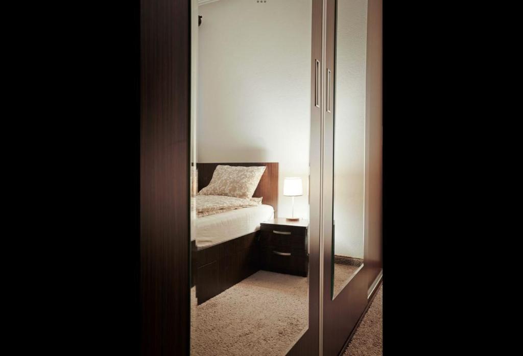 a mirror in front of a bedroom with a bed at Csilla Vendégház Remete in Remetea