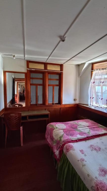 鲁滕Rima Hostel Ruteng的带床、书桌和窗户的卧室
