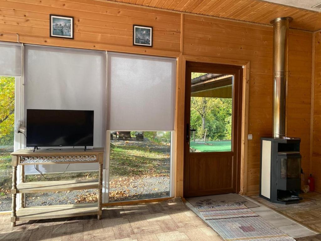 a living room with a tv and a sliding glass door at Панорама Шаян in Shaian