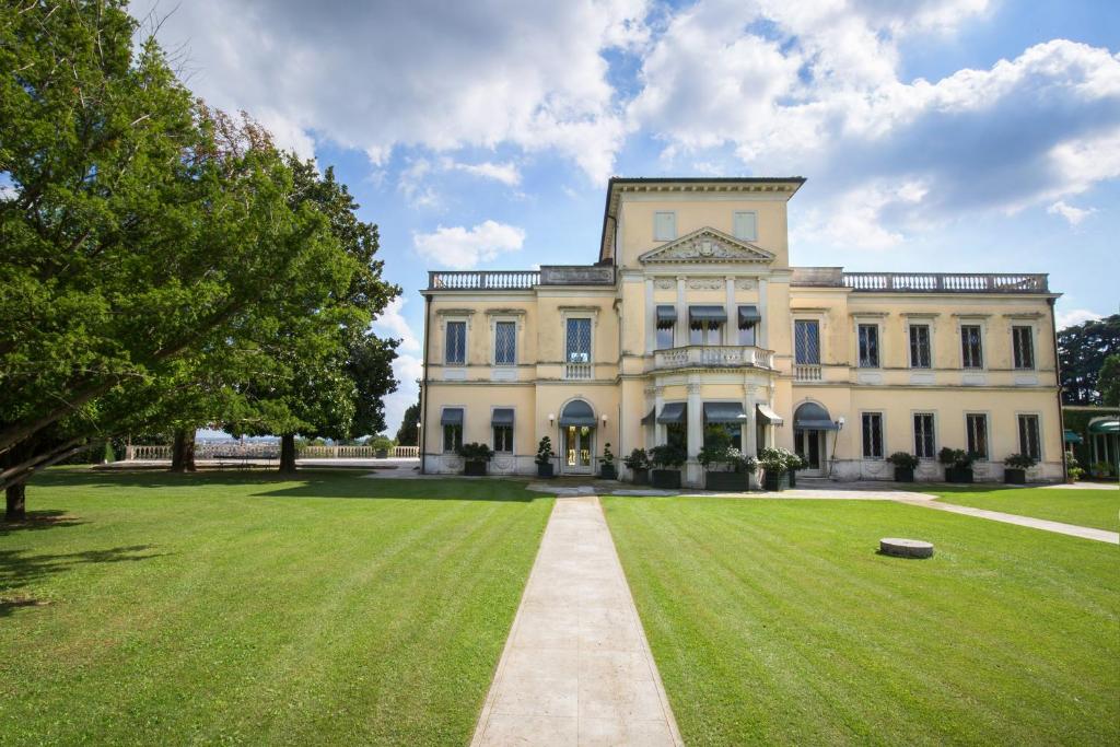 a large house with a grassy yard in front of it at Villa del Cavaliere Berico in Vicenza