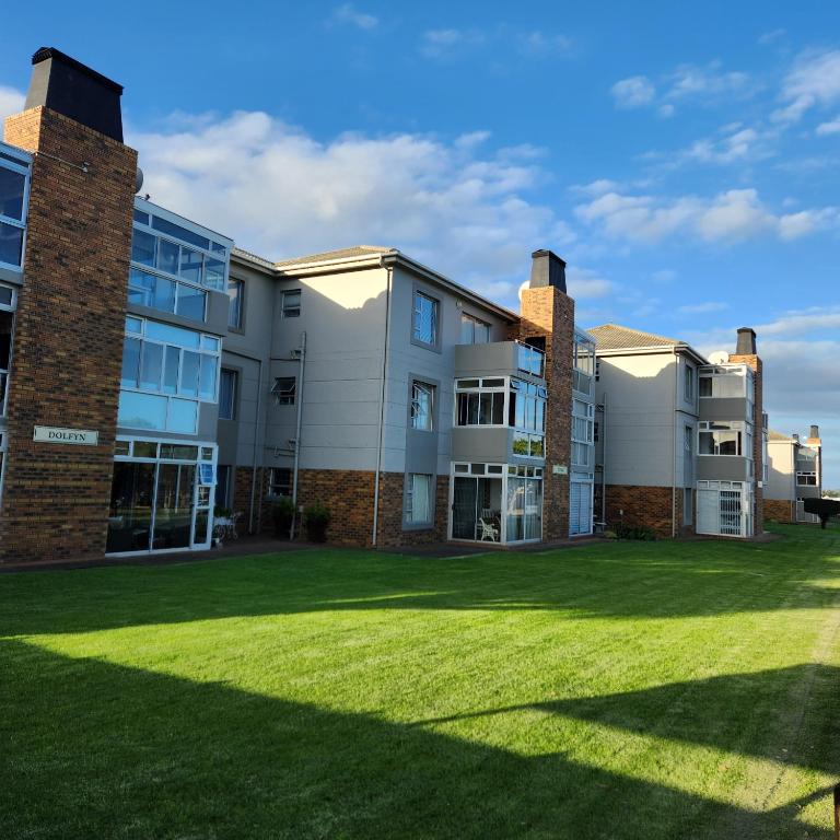 an exterior view of a building with a lawn at Dolfyn201 La Mer in Hartenbos