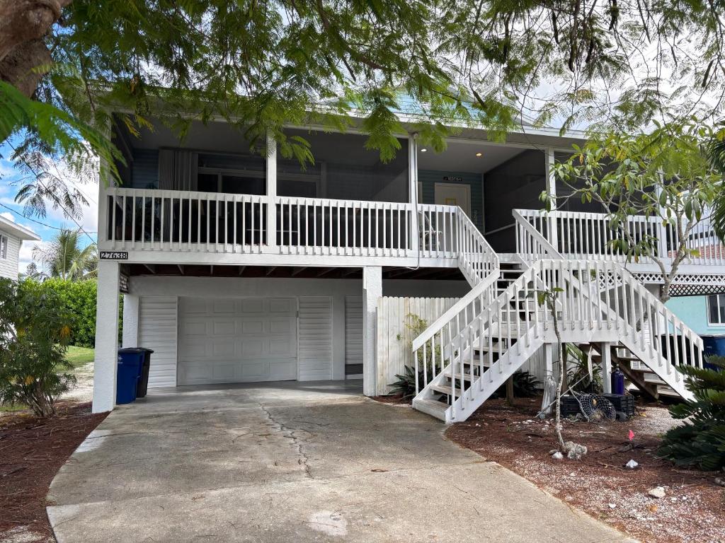 a house with a white staircase leading to a garage at Tarpon - Spacious Updated W&D Full Kitchen 1.5 Mi to Beach in Bonita Springs