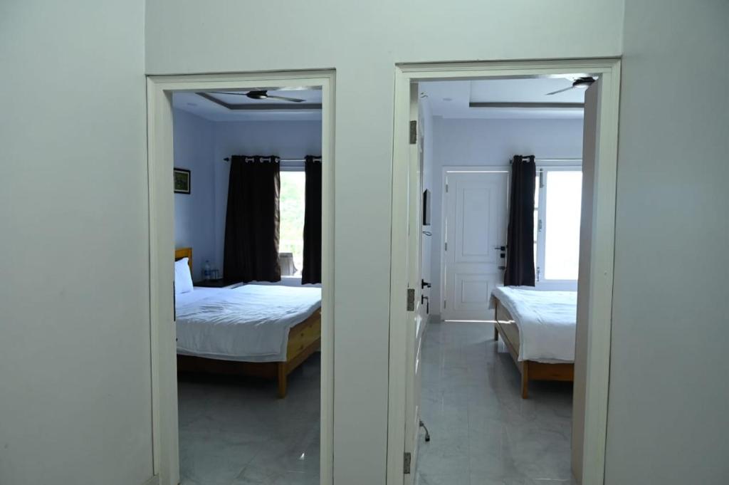 una camera da letto con due letti e uno specchio di Mansarovar Heritage Inn ad Almora