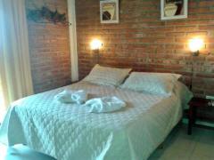 une chambre avec un lit blanc avec des serviettes dessus dans l'établissement Antawara, à Merlo