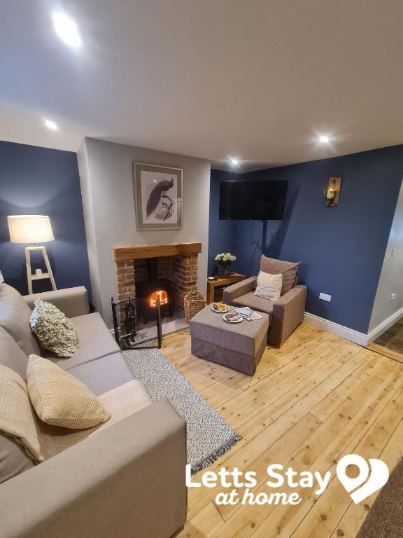 a living room with a couch and a fireplace at Coachway Cottage in Ilkley