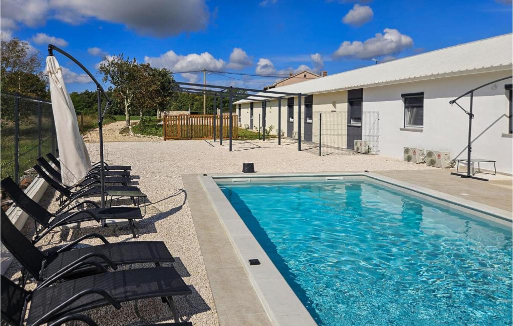 una piscina con due sedie e un ombrellone di Cozy Home In Zminj a Jurići