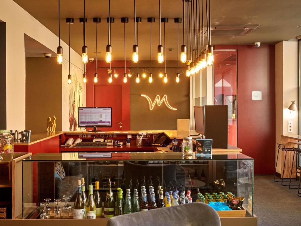 ein Restaurant mit einer Bar mit Weinflaschen in der Unterkunft Mercure Barcelona Condor in Barcelona