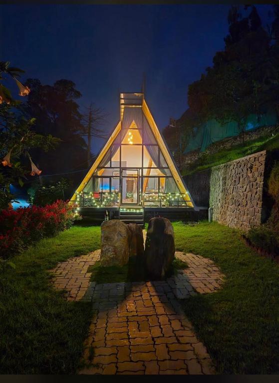 a small house with a glass facade at night at Lux Lake View Aframe - Skyframe in Kodaikānāl
