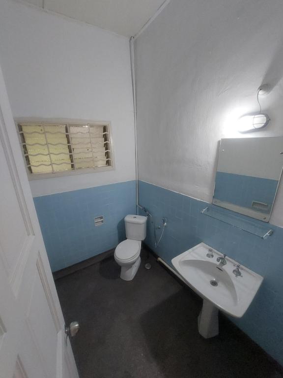 Un baño azul y blanco con inodoro y lavabo. en A Borneo Guesthouse, en Johor Bahru