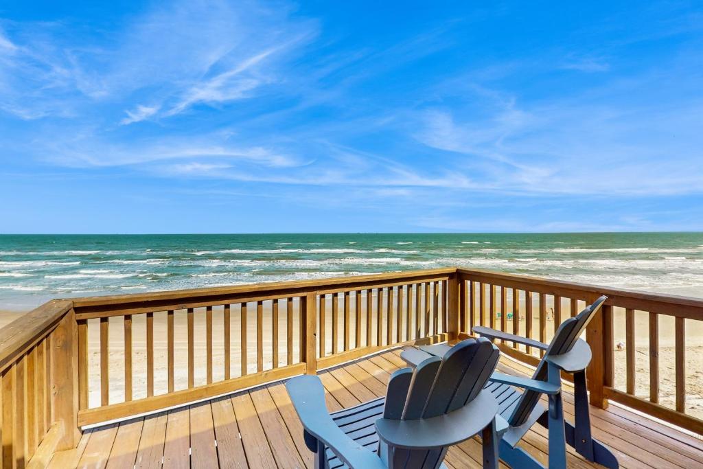two chairs sitting on a deck overlooking the ocean at Colony Make A Splash in Padre Island