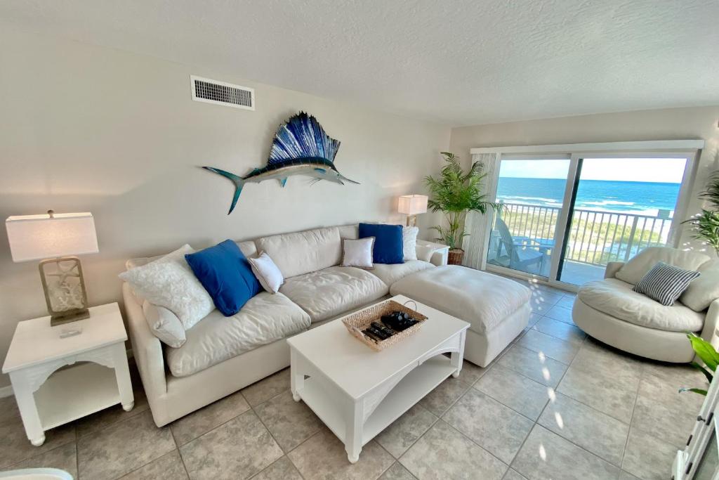 a living room with a couch and a table at Sailfish Sands in Cocoa Beach
