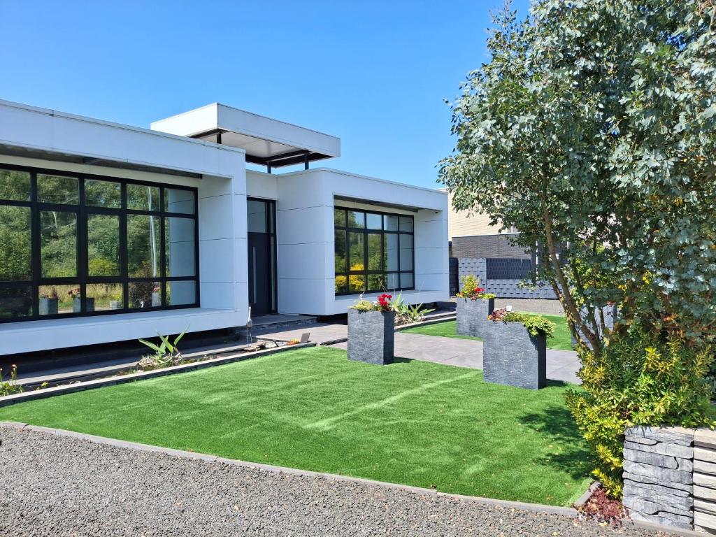 a white house with a green lawn in front of it at B&B DownUnder in Vlissingen