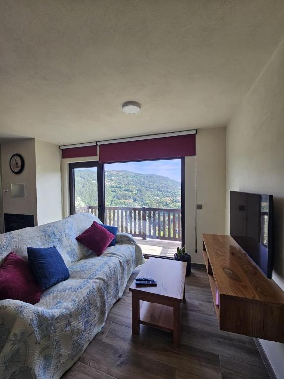a living room with a couch and a large window at Casa dos Pobres in Castro Daire