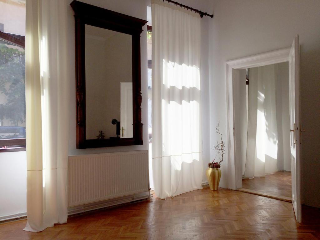a room with a mirror and a hallway with white curtains at Contessa Apartment Cluj Napoca in Cluj-Napoca