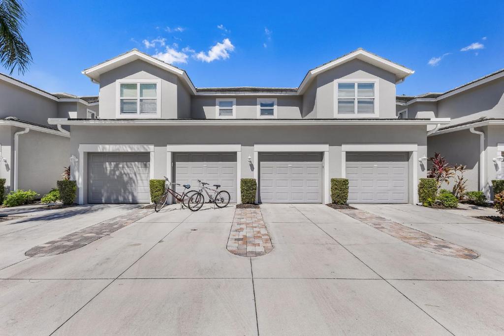a house with two bikes parked in a driveway at Relaxed Golfside Living with New Furnishings & Scenic Views - Palm Breeze Fairway in Gateway