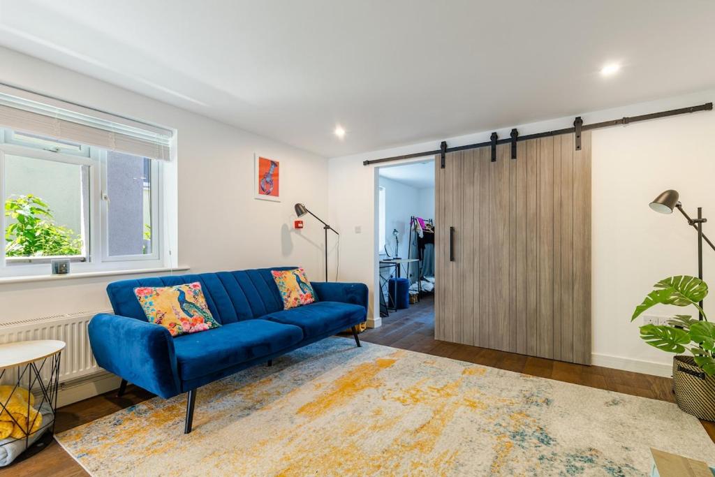 ein Wohnzimmer mit einem blauen Sofa und einer Schiebetür in der Unterkunft Salcombe Hideaway in Salcombe