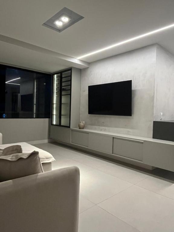a living room with a flat screen tv on a wall at Quarto Individual e Privativo - Apt moderno compartilhado com o Hoster - Boa Viagem in Recife