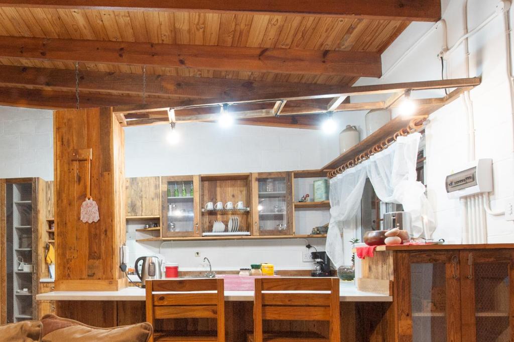 Una cocina con gabinetes de madera y una mesa con sillas. en Wild Eden Self-Catering Accommodation, en Swakopmund