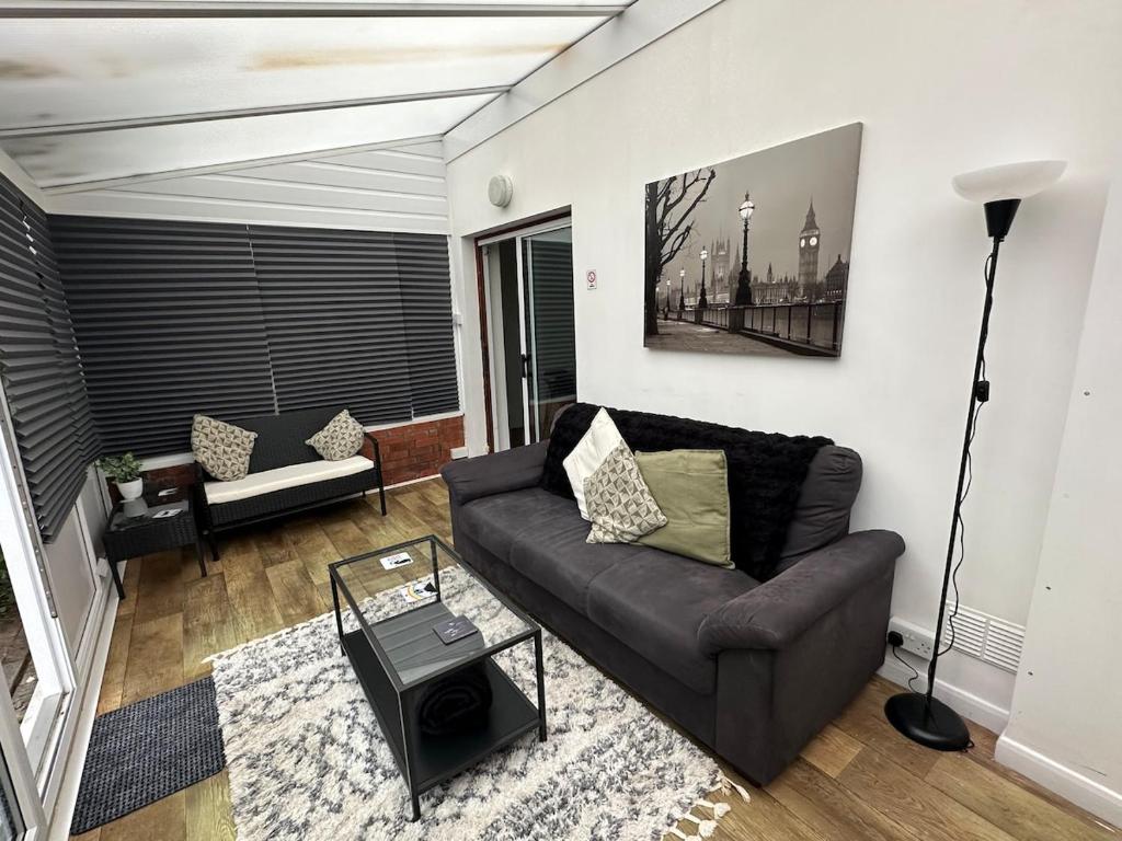 a living room with a couch and a table at 3 bedroom house, stones throw from SMH in Bristol